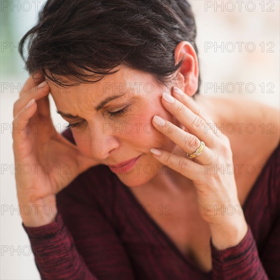 Portrait of mature woman with hands on head