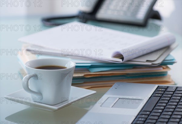 Close-up of coffee, paper material , laptop and telephone