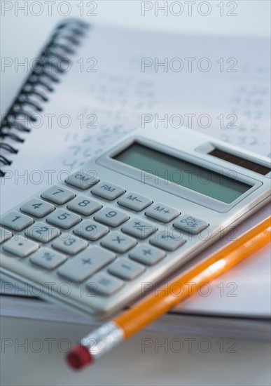 Studio Shot of calculator pen and spiral-bound notebook