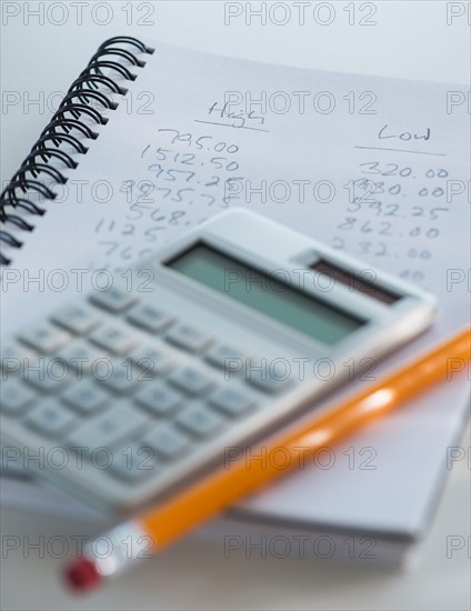 Studio Shot of calculator pen and spiral-bound notebook