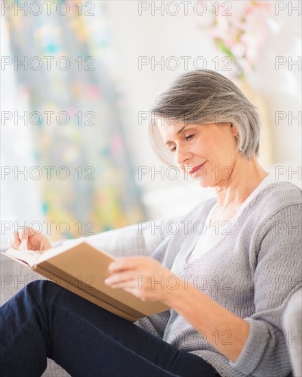 Portrait of woman reading on sofa