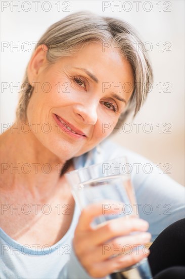 Portrait of woman holding glass of water