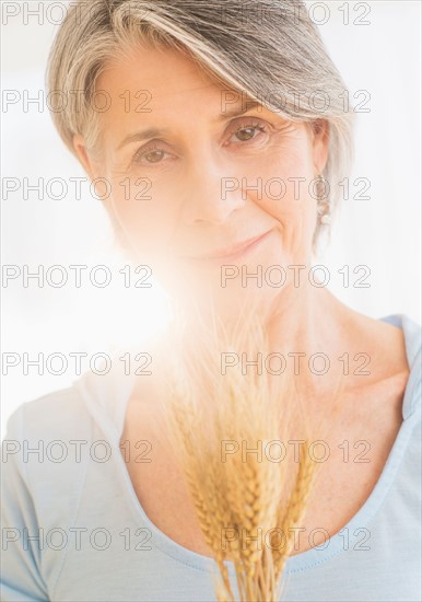 Portrait of pensive woman holding dry wheat