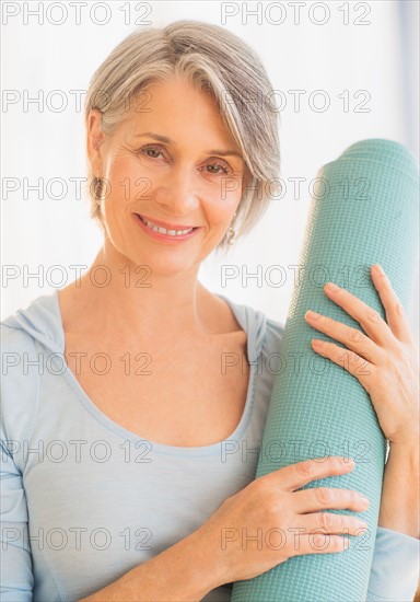 Portrait of woman holding yoga mat