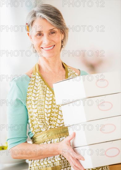 Portrait of woman carrying boxes