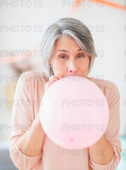 Portrait of woman blowing balloon