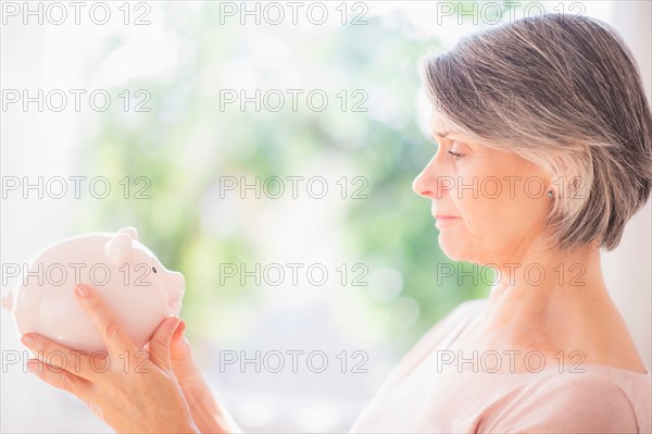 Portrait of woman holding piggy bank