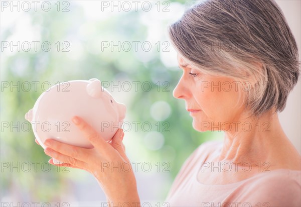 Portrait of woman holding piggy bank