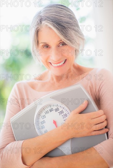 Portrait of woman holding bathroom scale