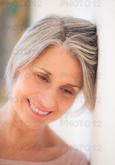 Portrait of relaxed woman leaning against wall