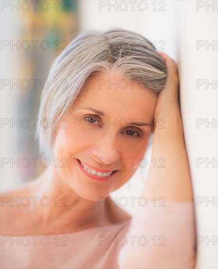 Portrait of relaxed woman leaning against wall