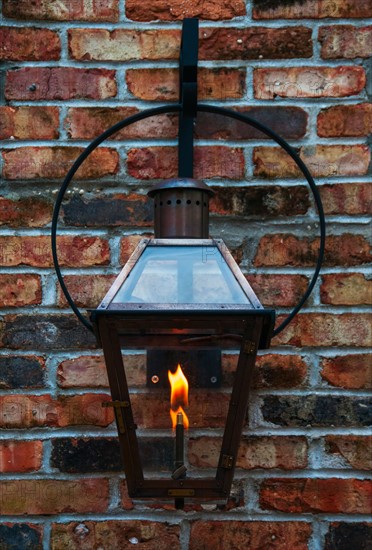 Close up of lantern hanging on brick wall