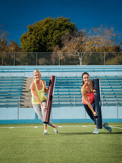 Two women exercising at sports field