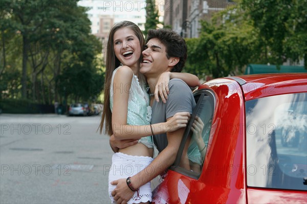 Young couple embracing standing by car