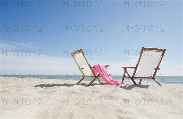 empty lounge chairs on sandy beach