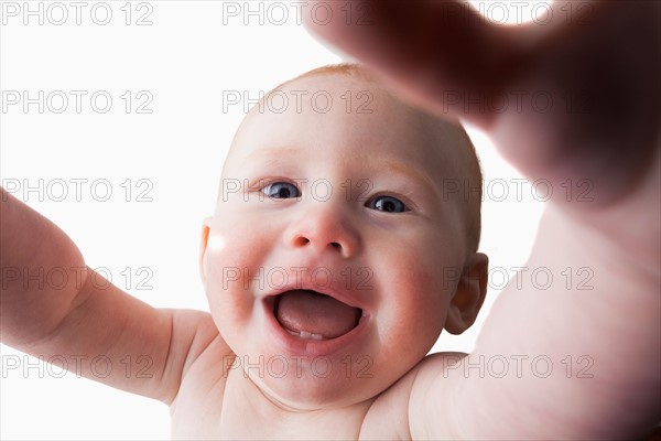 Studio shot of baby boy (18-23 months) reaching camera