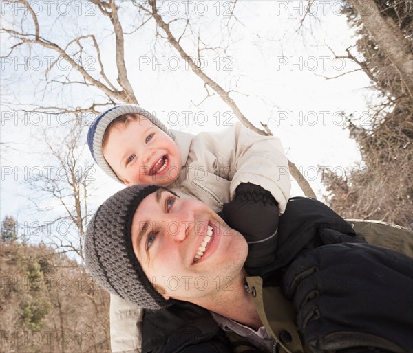 Young man carrying his son (12-17 months) on shoulders