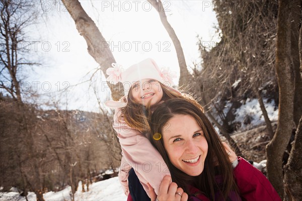 Young woman carrying her daughter (2-3) on shoulders