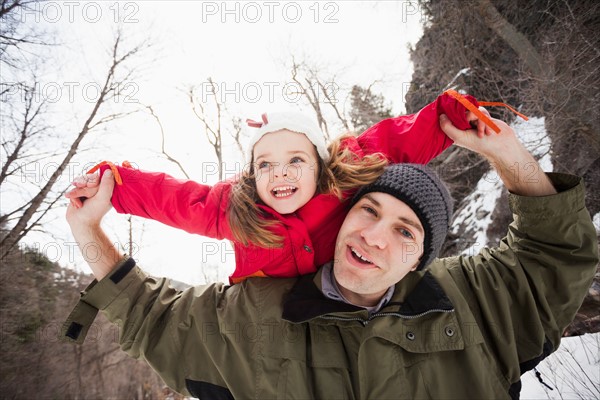 Portrait of young man carrying girl (2-3) on shoulders