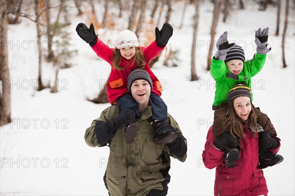 Portrait of parents carrying children (2-3, 4-5) on shoulders