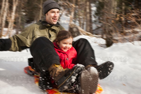 Young man sledding with girl (2-3)