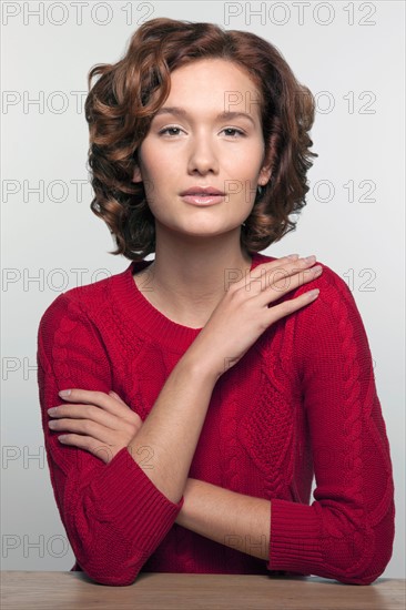 Studio shot portrait of young woman in red pullover