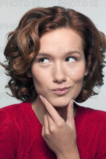 Studio shot portrait of young woman in red pullover