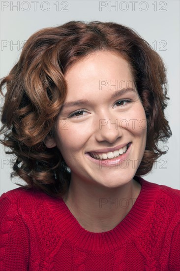 Studio shot portrait of young woman in red pullover