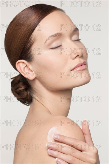 Studio shot portrait of young woman with eyes closed