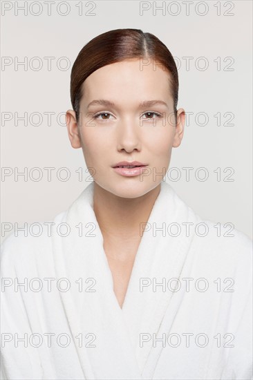 Studio shot portrait of young woman in bathrobe