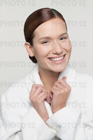 Studio shot portrait of young woman in bathrobe