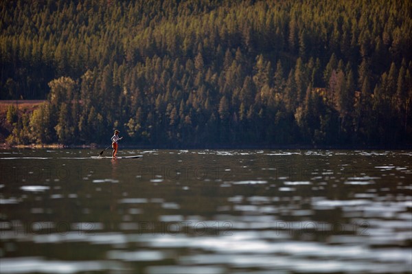 Woman paddleboarding on lake