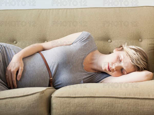 Pregnant woman lying on sofa sleeping