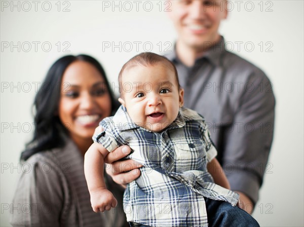 Portrait of happy multiethnic family with baby boy (2-5 months) on front