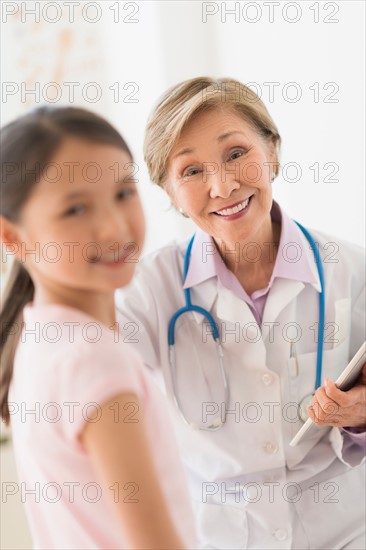 Portrait of doctor and girl (8-9) in foreground.