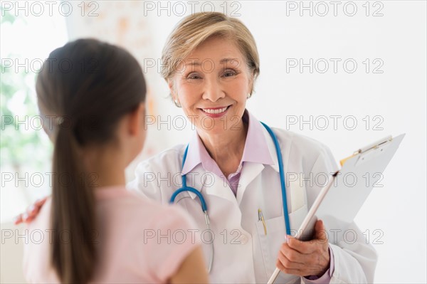 Portrait of doctor and girl (8-9) in foreground.