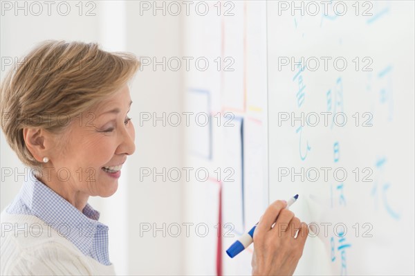 Teacher writing at whiteboard.