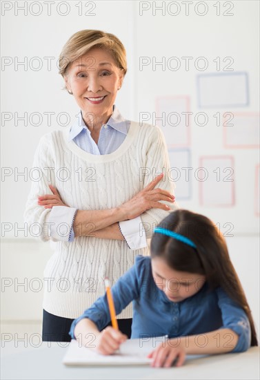 Teacher and schoolgirl (8-9) at school.