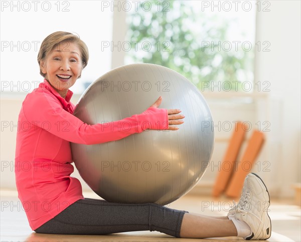Senior woman exercising with fitness ball.