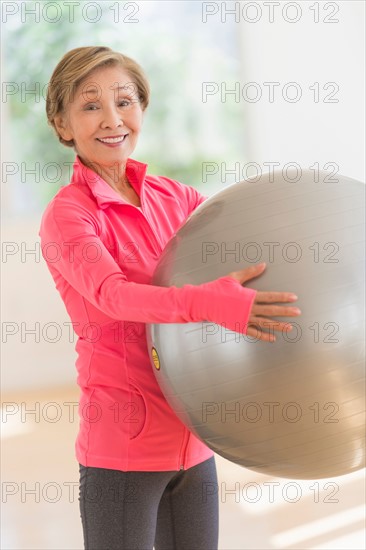 Senior woman exercising with fitness ball.