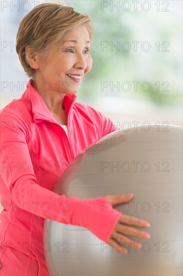 Senior woman exercising with fitness ball.