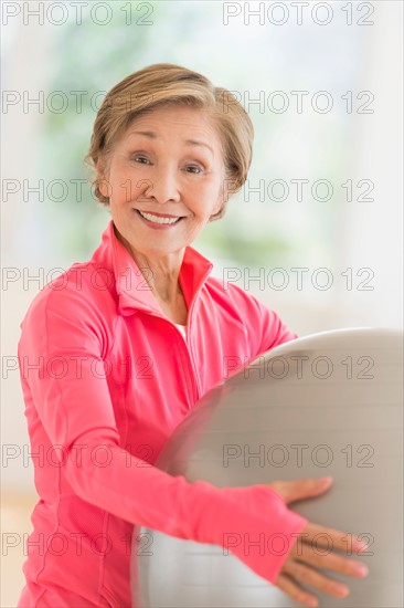 Senior woman exercising with fitness ball.