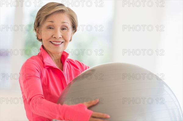 Senior woman exercising with fitness ball.