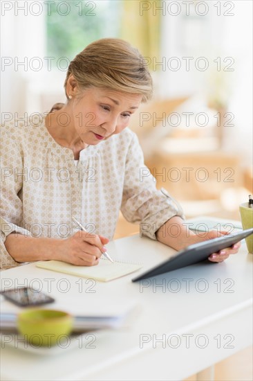 Senior woman using tablet pc at home.