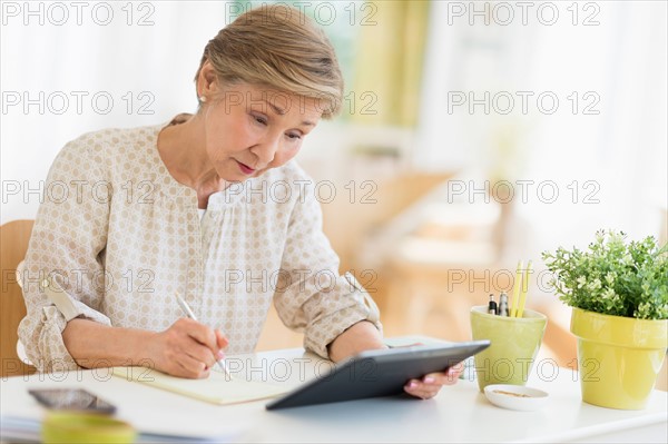 Senior woman using tablet pc at home.