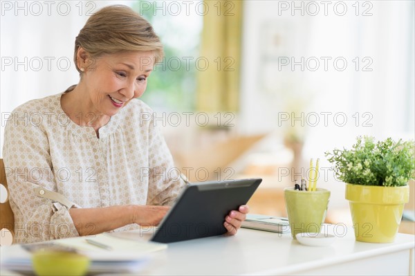 Senior woman using tablet pc at home.