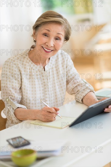 Senior woman using tablet pc at home.