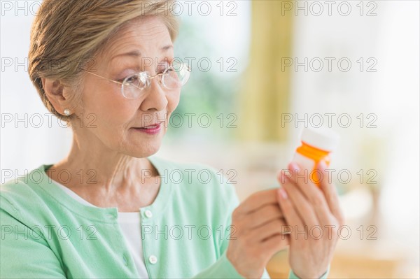 Senior woman reading medicine label.