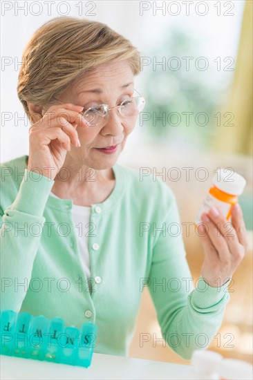 Senior woman reading medicine label.