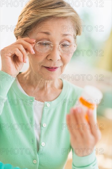 Senior woman reading medicine label.